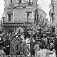 4. JUAN JOSÉ SERRANO GÓMEZ. Nuestro Padre Jesús de la Salud de la Hermandad de los Gitanos en la mañana del Viernes Santo. 1922-1923 La cofradía acaba de pasar por la estrecha calle Imagen junto a la iglesia de San Pedro y la calle Alcázares, actual Santa Ángela de la Cruz. A la izquierda, la calle Bolsa, desaparecida tras el ensanche urbanístico de finales de 1940. © ICAS-SAHP, Fototeca Municipal de Sevilla, Archivo Serrano