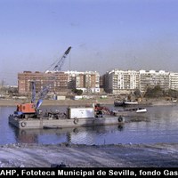 Obras para la EXPO’92. Trabajos de dragado en el río Guadalquivir. Detrás, la calle Radio Sevilla y las obras de apertura de la calle Jándalo y la ordenación de los Jardines de Chapina. 1991. ©ICAS-SAHP, Fototeca Municipal de Sevilla, fondo Gasán