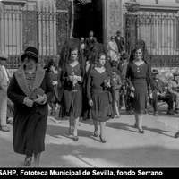 Oficios del Jueves Santo en 1929. Salida de fieles de la iglesia colegial del Divino Salvador. La plaza presentaba aún reminiscencias del “paseo de salón” proyectado por Balbino Marrón en 1846. Esta distribución con arboleda central y bancos con respaldo de hierro sufriría varias reformas con sucesivos estrechamientos hasta la década de 1940.  ©ICAS-SAHP, Fototeca Municipal de Sevilla, fondo Serrano