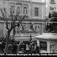 Juan Martínez Montañés, en su tribuna de privilegio contempla el paso de Jesús de las Tres Caídas de San Isidoro. El monumento, obra de Sánchez Cid,  había sido colocado en la plaza en 1923.  Aún quedan los árboles que formaban parte del antiguo “paseo de salón” diseñado por Balbino Marrón. ©ICAS-SAHP, Fototeca Municipal de Sevilla, fondo Serrano