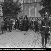 La reina Victoria Eugenia de Battenberg, ataviada con mantilla negra, en la plaza del Triunfo en dirección al Alcázar acompañada de sus damas tras asistir en la Catedral a los oficios religiosos. 2 de mayo de 1927. ©ICAS-SAHP, Fototeca Municipal de Sevilla, fondo Sánchez del Pando