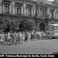 Grupo de turistas bajando del autobús en la plaza Virgen de los Reyes para la visita de la Catedral y la Giralda. Agosto de 1969. ©ICAS-SAHP, Fototeca Municipal de Sevilla, fondo Gelán