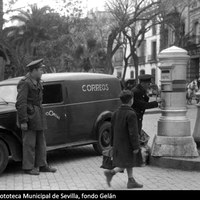 Funcionarios de Correos recogiendo cartas del buzón ubicado en la Plaza del Duque de la Victoria. Detrás, el colegio Alfonso X el Sabio y el palacio de Sánchez-Dalp. 1952. ©ICAS-SAHP, Fototeca Municipal de Sevilla, fondo Gelán