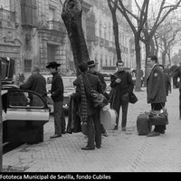 Grupo de músicos subiendo a un taxi en la plaza del Duque de la Victoria. Quizá han actuado en el cercano tablao El Patio Andaluz. 1960 ca. ©ICAS-SAHP, Fototeca Municipal de Sevilla, fondo Cubiles