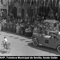 Festividad de San Cristóbal, patrón de los automovilistas. Bendición de vehículos oficiales y particulares en la Plaza del Salvador. Un coche de bomberos del Servicio Municipal de Incendios pasa ante el párroco de la Colegial. 10 de julio de 1951.  ©ICAS-SAHP, Fototeca Municipal de Sevilla, fondo Gelán