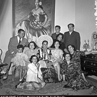 2. Carmen Sevilla a su regreso de México. Ataviada con el traje típico mexicano, posa con sus padres Antonio García y Florentina Galisteo, su hermano y otros familiares ante el cuadro que le pintó vestida de flamenca Manuela Delsors Mangrané. Madrid, 1953 ©ICAS-SAHP, Fototeca Municipal de Sevilla, fondo Basabe