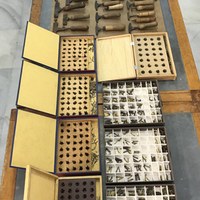 Conjunto de herramientas para el dorado a mano. Son herramientas grabadas a buril sobre una pieza de bronce que  imprimen por calor y la presión de la mano el dibujo grabado en la misma. Se pueden ver las cajas de tipografía para mano también grabadas en bronce. ©ICAS-SAHP, Dpto. Reprografía