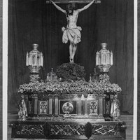 Santísimo Cristo de la Buena Muerte en el paso antes de la salida en su primera Estación de Penitencia en 1926. Los faroles que enmarcan la figura del crucificado se utilizarían durante años colocados en la puerta de la iglesia de la Anunciación. ©ICAS-SAHP, Fototeca Municipal de Sevilla, fondo Serrano