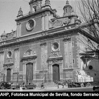 Aspecto de la plaza a mediados de la década de los 50 del siglo XX. La cruz de madera que ocupa el chaflán con la calle Villegas, es conocida como “Cruz de las Culebras” y la lápida que figura a sus pies, fechada en 1714, hace referencia a la ley del rey Juan I y por la que se castigaba a todo el que no se arrodillase al paso de Jesús Sacramentado. ©ICAS-SAHP, Fototeca Municipal de Sevilla, fondo Serrano