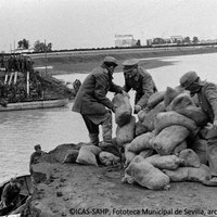 3. Primeras intervenciones de la Compañía de Zapadores colocando sacos terreros para taponar la brecha principal. Detrás, la autopista de San Pablo y la fábrica de cervezas Cruzcampo. 26 de noviembre de 1961 ©ICAS-SAHP, Fototeca Municipal de Sevilla, archivo Serrano
