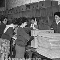 15. La labor de selección y envasado de alimentos en las cajas repartidas fue llevada a cabo por numerosas voluntarias. A cada familia damnificada se le entregarían además 50 huevos y 5 kilos de patatas. Diciembre de 1961 ©ICAS-SAHP, Fototeca Municipal de Sevilla, archivo Serafín