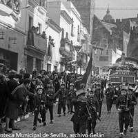 21. Caravana de la Operación Clavel encabezada por el vehículo con la imagen de María Auxiliadora y precedida por la banda infantil del Colegio Salesiano. Carmona. 19 de diciembre de 1961 ©ICAS-SAHP, Fototeca Municipal de Sevilla, archivo Gelán
